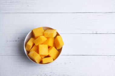 Beyaz ahşap zemin üzerinde bir kase mango sükse düz uzanıyordu.