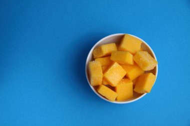 Beyaz kase mango suckatdes mavi arka planda izole düz la