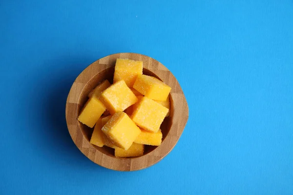 Tazón de madera de mango sucesiones aisladas sobre fondo azul plana l — Foto de Stock