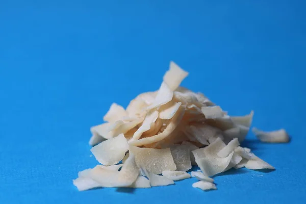 a pile of coconut chips isolated on blue background