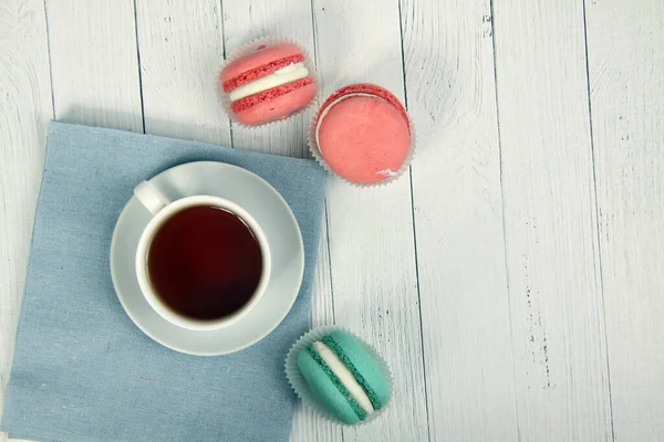 Macaroons Cores Diferentes Uma Xícara Chá Guardanapo Lona Fundo Madeira — Fotografia de Stock