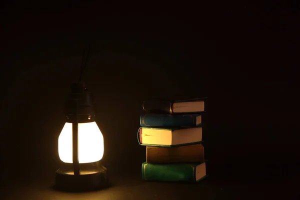 Une Pile Livres Une Lampe Essence Isolée Sur Fond Noir — Photo