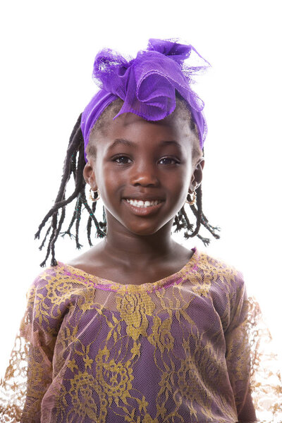 Beautiful portrait of a happy African little girl smiling in purple costume on white background