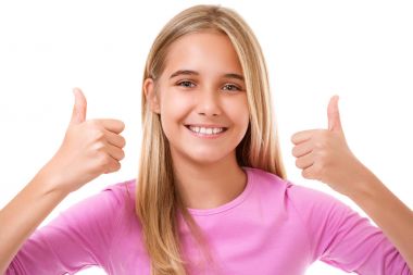 Tamam el işareti ile mutlu gülümseyen genç kız. İzole