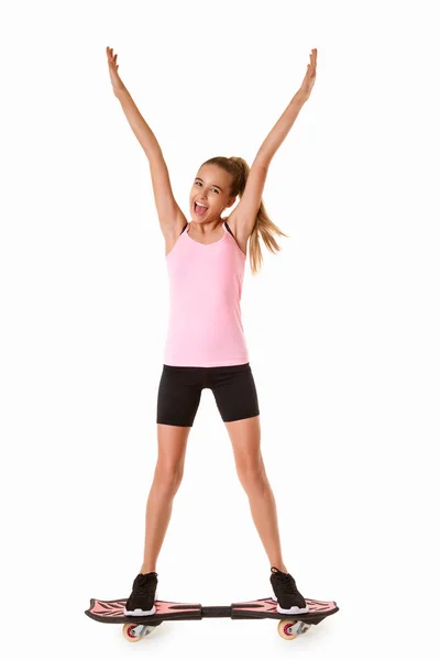 Cheerful sporty teen girl standing on waveboard with hands up,isolated — Stock Photo, Image