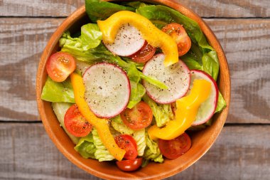 Çünkü marul, domates, biber, turp ahşap zemin üzerine salata taze sağlıklı yakından.