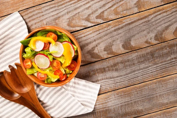 Taze sağlıklı Salata marul, domates, biber, turp ahşap arka plan üzerinde