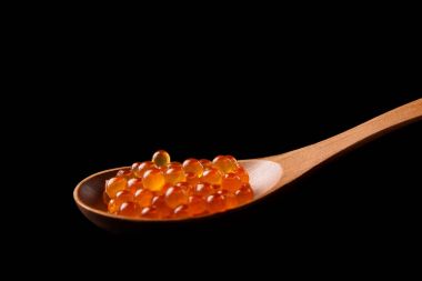 tahta kaşık siyah zemin üzerine kırmızı havyar. 