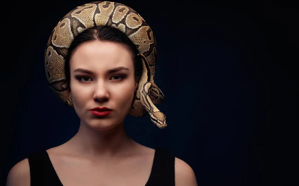 De cerca retrato de mujer con serpiente alrededor de su cabeza en ba oscuro — Foto de Stock