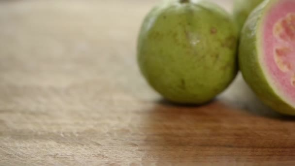 Guayaba Rosa Cortada Gira Sobre Mesa Madera — Vídeo de stock