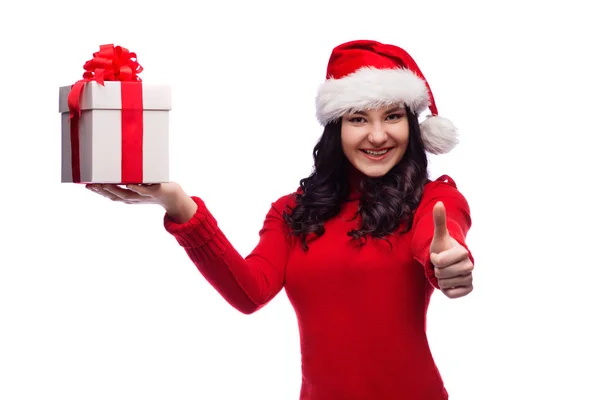 Happy brunette young woman with santa hat and christmas box showing ok hand sign, isolated — стоковое фото