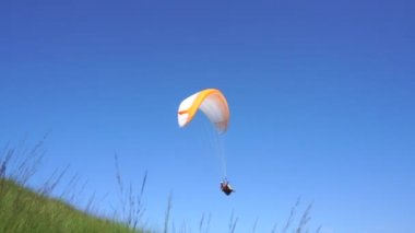 Güneşli bir günde Paraglider İtalya 'nın mavi gökyüzüne karşı Mottarone Dağı' nda uçuyor