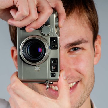 Film kamerasıyla fotoğraf çeken genç bir fotoğrafçının portresi.