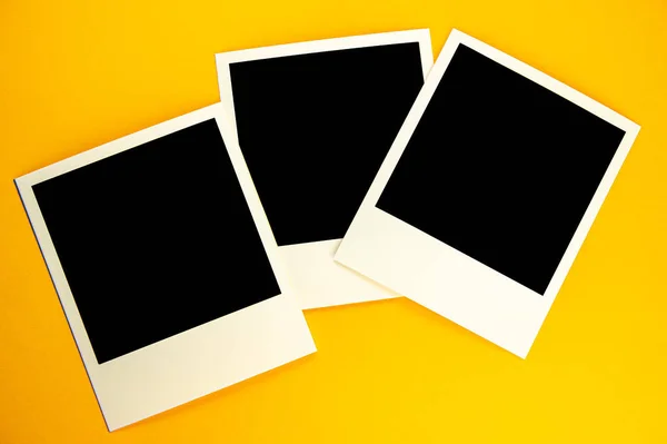 Tres fotos con la imagen de un cuadrado negro yacen en una ba amarilla —  Fotos de Stock