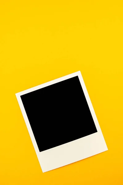 Фотографія з зображенням чорного квадрата лежить на жовтому фоні — стокове фото