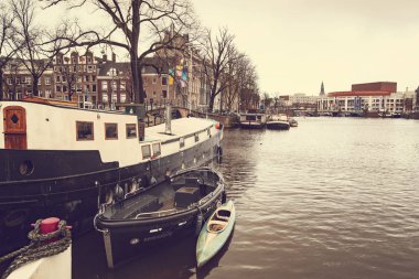 AMSTERDAM, NETHERLANDS - Aralık 2019: tipik Amsterdam şehri. Amsterdam kanalları, tekneler ve Hollanda mimarisi, Hollanda