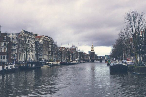 AMSTERDAM, NETHERLANDS - December 2019: Typical Amsterdam cityscape. Amsterdam canals, boats and dutch architecture, Netherlands