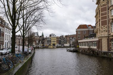 AMSTERDAM, NETHERLANDS - Aralık 2019: tipik Amsterdam şehri. Amsterdam kanalları, tekneler ve Hollanda mimarisi, Hollanda