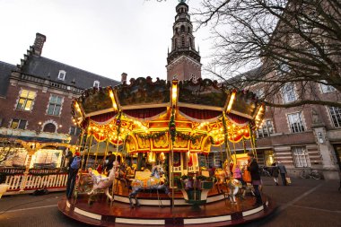 Leiden, Hollanda - Aralık 2019: Hollanda 'daki Leiden kasabasının gece manzarası. Hollanda, Leiden 'da akşam saatlerinde şehir merkezinde bir atlıkarınca.