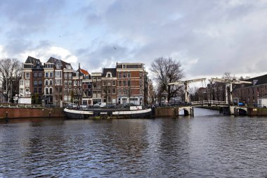 AMSTERDAM, NETHERLANDS - December 2019: Typical Amsterdam cityscape. Amsterdam canals, boats and dutch architecture, Netherlands