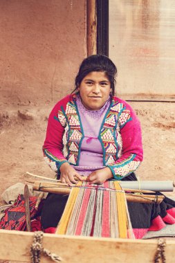 Cusco, Peru - Aralık 2019 Perulu kadın iş başında. Cusco, Peru 'da alpaka yününden renkli atkı ören kadın.