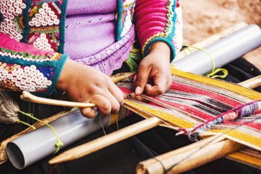 Cusco, Peru - Aralık 2019 Perulu kadın iş başında. Cusco, Peru 'da alpaka yününden renkli atkı ören kadın.