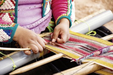 Cusco, Peru - Aralık 2019 Perulu kadın iş başında. Cusco, Peru 'da alpaka yününden renkli atkı ören kadın.