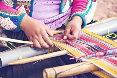 Cusco, Peru - Aralık 2019 Perulu kadın iş başında. Cusco, Peru 'da alpaka yününden renkli atkı ören kadın.