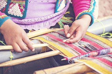 Cusco, Peru - Aralık 2019 Perulu kadın iş başında. Cusco, Peru 'da alpaka yününden renkli atkı ören kadın.