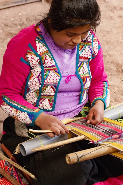 Cusco, Peru - Aralık 2019 Perulu kadın iş başında. Cusco, Peru 'da alpaka yününden renkli atkı ören kadın.