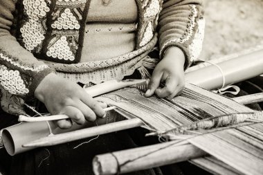 Cusco, Peru - Aralık 2019 Perulu kadın iş başında. Cusco, Peru 'da alpaka yününden renkli atkı ören kadın.
