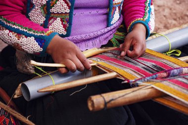 Cusco, Peru - Aralık 2019 Perulu kadın iş başında. Cusco, Peru 'da alpaka yününden renkli atkı ören kadın.