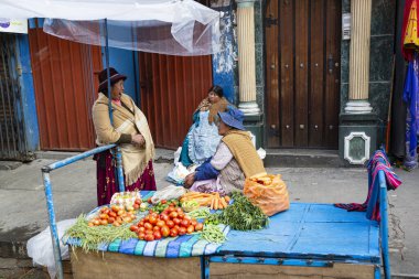 LA PAZ, BOLIVIA - January 2020: Bolivian woman wearing traditional dress (Cholitas) on the market in La Paz city, Bolivia. People of Bolivia. Traditional market in Bolivia.
