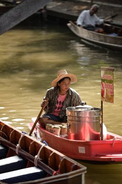 BANGKOK, THAILAND - Mart 2019: Tayland 'ın Bangkok şehrinden çok uzak olmayan Damnoen Saduak Yüzen Pazarı' nda gıda ve sebze satan insanlar