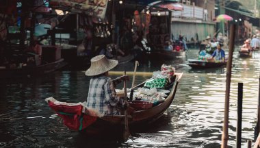 BANGKOK, THAILAND - Mart 2019: Tayland 'ın Bangkok şehrinden çok uzak olmayan Damnoen Saduak Yüzen Pazarı' nda gıda ve sebze satan insanlar