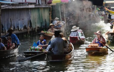 BANGKOK, THAILAND - Mart 2019: Tayland 'ın Bangkok şehrinden çok uzak olmayan Damnoen Saduak Yüzen Pazarı' nda gıda ve sebze satan insanlar