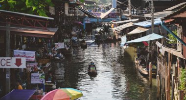 İnsanlar Bangkok, Tayland 'a yakın Damnoen Saduak Yüzen Pazarı' nda sebze ve yiyecek satıyor.