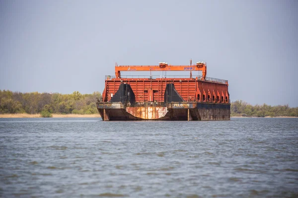 Yaşlı yıpranmış kırmızı ve siyah mavna nehir kenarına demirlemiş.