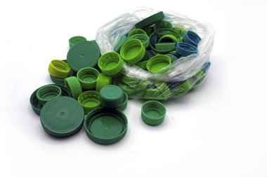 Yeşil plastik kapaklar şeffaf tek kullanımlık plastik poşetlerdeki renklere göre sıralanmış. Evcil Hayvan Kirliliği.