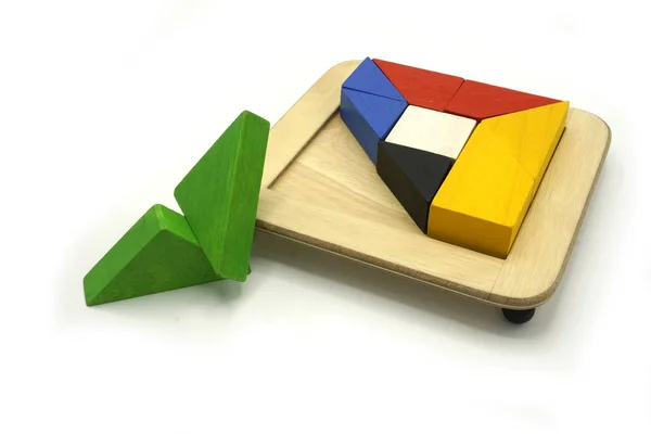 Танграм, китайська традиційна гра в пазл, зроблена з різних барвистих дерев "яних елементів, які сходяться в окремій формі, в дерев" яному ящику.. — стокове фото