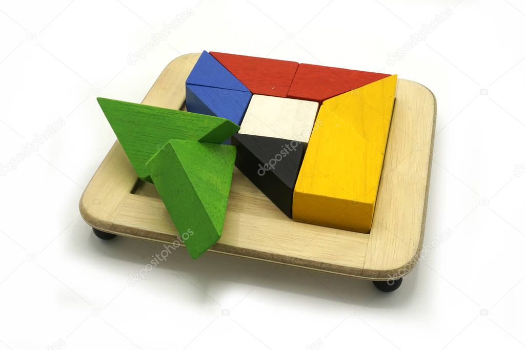Tangram, Chinese traditional puzzle game made of different colorful wooden pieces that come together in a distinct shape, in a wooden box.