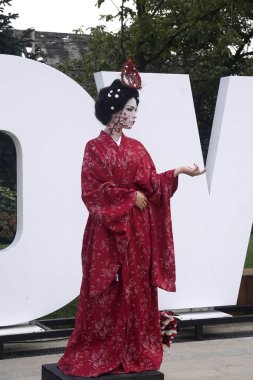 Timisoara, Romania- 09.06.2019 Living statue of a Japanese geisha. Woman dressed in kimono pose as a realistic human statue. clipart