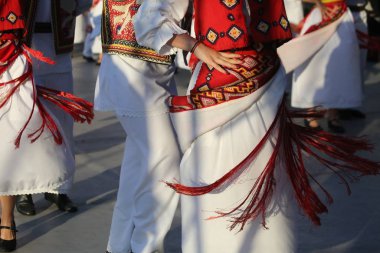 Dansçılar geleneksel bir Romanya dansında geleneksel güzel kostümler giyerek el ele tutuşuyorlar.