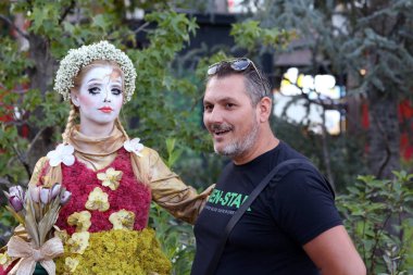 Timisoara, Romanya- 09.06.2019 Doğa Tanrıçası Flora. Çiçek takmış ve elinde buket olan kostümlü bir kadın gerçekçi bir insan heykeli gibi duruyor..