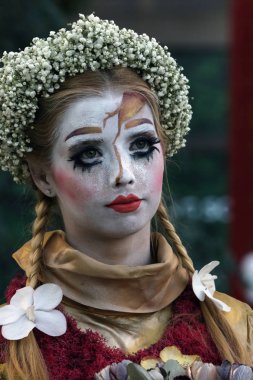 Timisoara, Romanya- 09.06.2019 Doğa Tanrıçası Flora. Çiçek takmış ve elinde buket olan kostümlü bir kadın gerçekçi bir insan heykeli gibi duruyor..