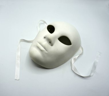 Tiyatro konsepti. Beyaz arkaplanda beyaz klasik tiyatro maskesinin yakın çekimi.