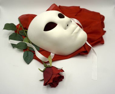 Tiyatro ya da aşk konsepti. Beyaz klasik tiyatro maskesi ve kırmızı gül cinsel özgürlüğün sembolü..