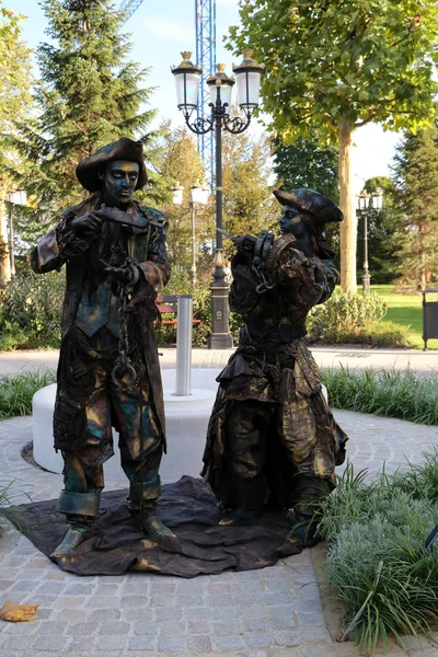 Timisoara, Romania- 09.06.2019 Living statue of two pirates. Woman and man dressed in bronze costumes with hats and weapons pose as a realistic human statue. — Stock Photo, Image