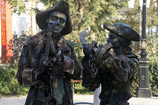 Timisoara, Romania- 09.06.2019 Living statue of two pirates. Woman and man dressed in bronze costumes with hats and weapons pose as a realistic human statue. — Stock Photo, Image