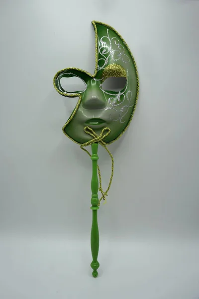 Zielona i złota tradycyjna wenecka maska karnawałowa na patyku na białym tle. — Zdjęcie stockowe